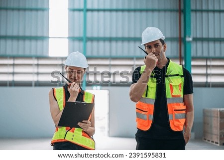 Portrait of engineers workers using talkie talking in empty warehouse to design the arrangement of product shelves.
