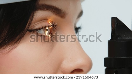 Close-up of a young woman having her vision tested on an ophthalmology diagnostic vision testing equipment. Professional ophthalmological apparatus. Royalty-Free Stock Photo #2391604693
