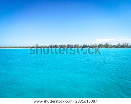 The scenic view of turquoise color waters on beach and rainy clouds in a background in Bahamas