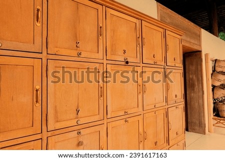 Wooden lockers in a locker room in the modern building, Locker room interior in modern fitness gym, free text space and empty room. Royalty-Free Stock Photo #2391617163
