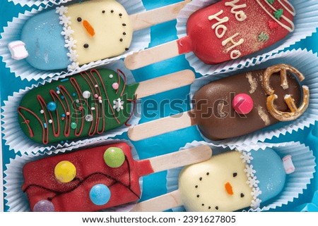 Christmas dessert. Sweet food. Cheesecake on a stick in the shape of ice cream. Children's treat in winter. Candy Christmas tree, snowman, deer and Santa Claus. Gingerbread cookies. Cakesicles