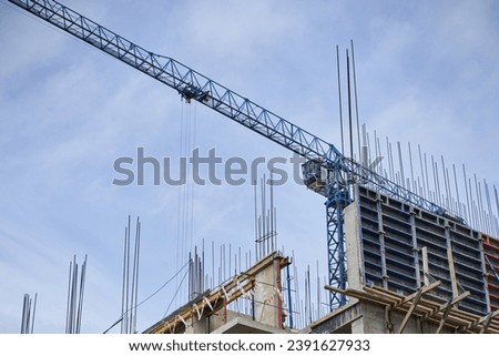 Construction site with a tower crane. Construction of residential buildings. View of a metal crane with space to copy. High quality photo