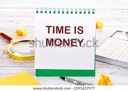 TIME IS MONEY text on the white sheet of the notebook is next to a magnifying glass, calculator, pencil, stickers