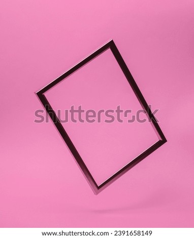 Golden frame levitates on a pink background. Minimal concept