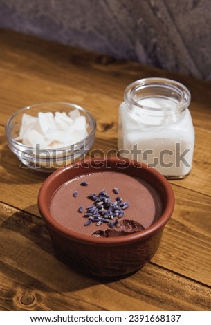Chocolate panna cota with coconut milk, vegan chocolate pudding with agar-agar and extra-dark cocoa powder. Coconut milk, chips and dry lavender, delicious Italian dessert Royalty-Free Stock Photo #2391668137