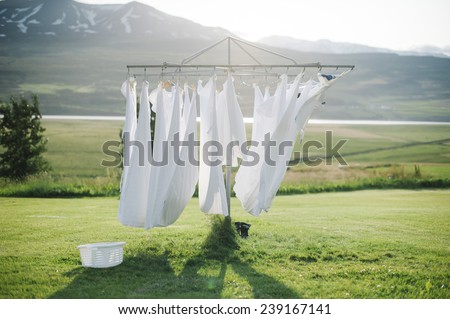 wet laundry  drying in the sun with the mountains on the background Royalty-Free Stock Photo #239167141