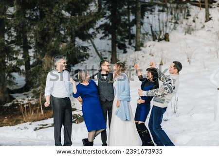 Weddings, couples and family celebrating marriage for commitment, trust or relationship support. Portrait of married bride and groom with happy parents. Wedding in winter Royalty-Free Stock Photo #2391673935