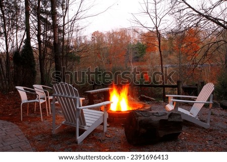 Empty Chairs and Benches Around a Campfire in Autumn