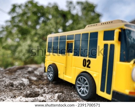 Yellow toy bus, photo from the side, blurry background