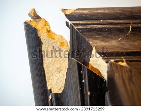  corner of the cabinet is broken. Crack in a wooden cabinet. Breakage when carrying furniture. Needs restoration. Boards Royalty-Free Stock Photo #2391715259