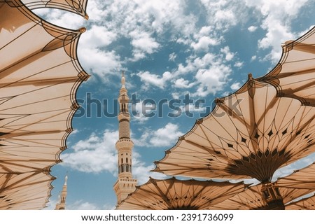 Umbrella Canopies Open At Nabawi Masjid Medina With Blue Beautiful Sky and Masjid Tower On The Background 