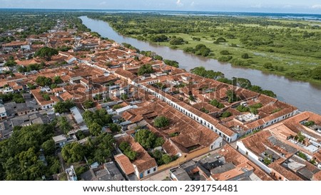 Aerial view of the historic town Santa Cruz de Mompox in sunlight with river and green sourrounding,