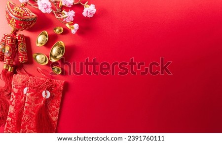 Chinese new year decorations made from red packet, orange and gold ingots or golden lump on a red background. Chinese characters FU in the article refer to fortune good luck, wealth, money flow.