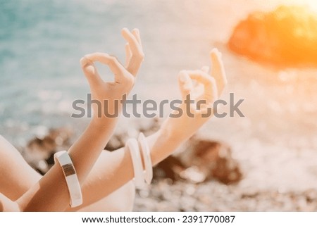 Close up Yoga Hand Gesture of Woman Doing an Outdoor meditation. Blurred sea background. Woman on yoga mat in beach meditation, mental health training or mind wellness by ocean, sea