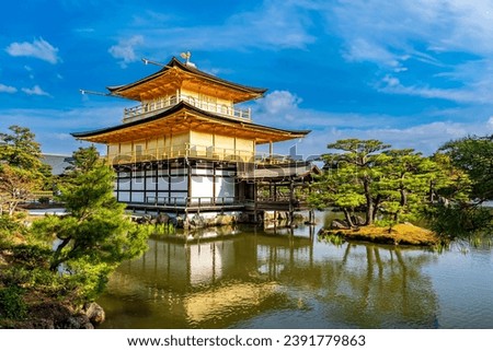 Kinkakuji Temple by the pond surrounded with Japanese garden in a blur foreground of bushes on the embankment Royalty-Free Stock Photo #2391779863