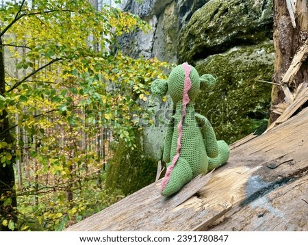 Dinosaur toy and backpack in the forest. Switzerland Bohemia Royalty-Free Stock Photo #2391780847