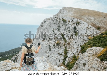 Woman taking pictures of mountains on hike walk journey