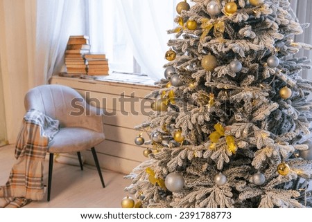 Interior of a white room with a snow-covered christmas tree with gifts