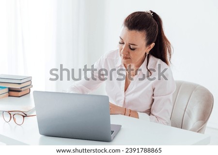 Business woman recording information from laptop