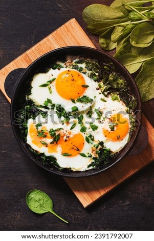 green shakshuka in a cast iron skillet. fried eggs with spinach and fried toast. healthy nutritious breakfast, Royalty-Free Stock Photo #2391792007