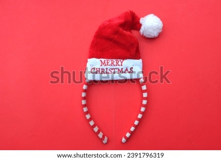 Beautiful headband 
 Decorative red Santa Hat isolate on a red backdrop.
concept of joyful Christmas party,New year is coming soon, festive season decoration with Christmas elements