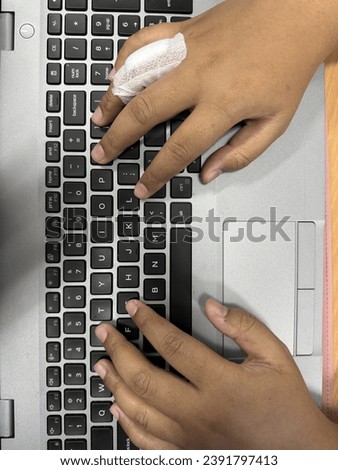 Hand of anonymous person typing on laptop keyboard at day, close up.