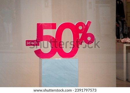 until 50% sale discount in french text tag label red offer price sign on street mall
