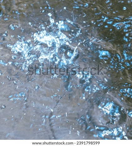 Splashes of water in a puddle from rain as an abstract background.