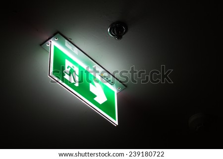 Emergency exit sign above a black doorway at night.