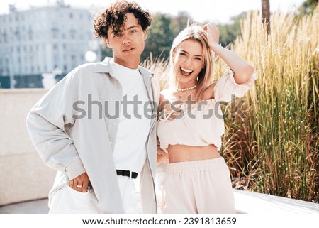 Young smiling beautiful woman and her handsome boyfriend in casual summer clothes. Happy cheerful family. Female having fun. Couple posing in the street background at sunny day
