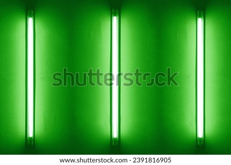 Three green neon bulbs on white wall. Background texture of empty old wall with glowing green neon bulbs.