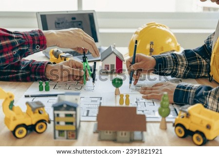 Concept architect, engineer, team holding pen, pointing architect, equipment on table with blueprints, ready to discuss home design in office.