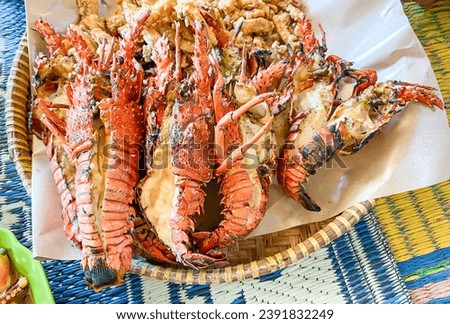 A pile of grilled sea lobster served on a woven bamboo plate. Concept for whole healthy food, omega-3, animal protein. Royalty-Free Stock Photo #2391832249