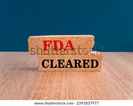 FDA, Food Drug Administration cleared symbol. Concept red words FDA cleared on brick blocks on a beautiful blue background. Business and FDA, Food Drug Administration cleared concept.