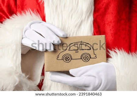 A gift box from a car, in the hand, in Santa Claus.