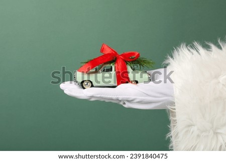 A car with New Year's decorations, in the hand, in the hands of Santa Claus.