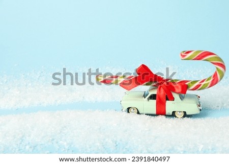 A car with Christmas candy on the roof and snow