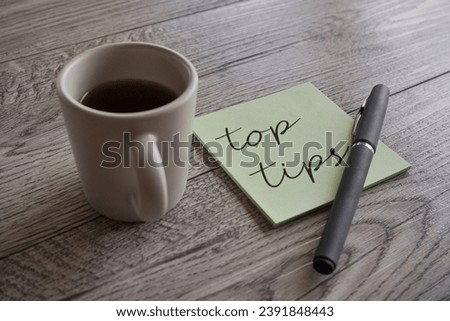 Closeup image of cup of coffee, pen and sticky note with text TOP TIPS.