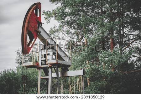 Deserted oil well with pumpjack. Abandoned gas rocking machine on the outskirts of the city. Concept of a resource crisis.