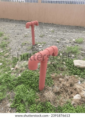 Red T-shaped pipes connected to an underground water tank