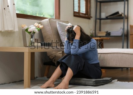 Young Asian woman suffering from stress sit alone at home, dejected. Desperate Asian woman feeling lonely Royalty-Free Stock Photo #2391886591