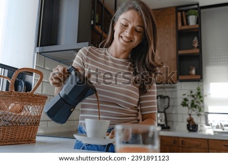 Beautiful young woman preparing coffee with a home espresso coffee maker Royalty-Free Stock Photo #2391891123