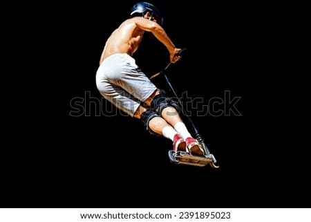 Young man practicing Scootering (Freestyle Scootering) at the SkatePark. Silhouette on dark background. Sports, youth, urban culture.