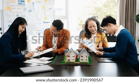 balancing the property sector The real estate agent is explaining the house style to see the house design and the purchase agreement.Wooden house at modern office