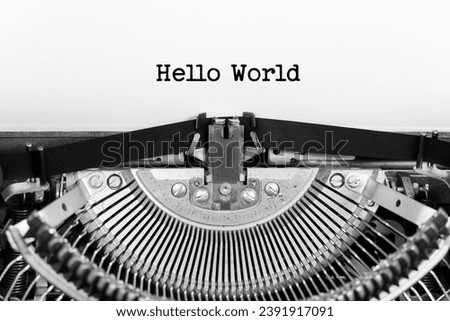 Hello World phrase closeup being typing and centered on a sheet of paper on old vintage typewriter mechanical Royalty-Free Stock Photo #2391917091