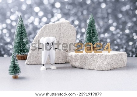 cartoon model of a tooth, the numbers 2024 on a podium made of stone and Christmas trees on a background of silver bokeh