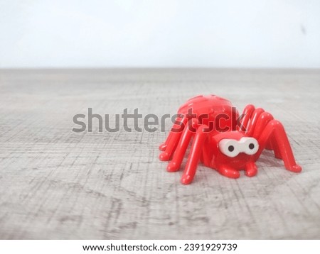 Red spider toy on light wooden background