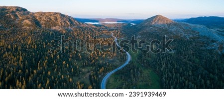 High angle aerial view of oad running through forest and mountainous landscape in northern Sweden Royalty-Free Stock Photo #2391939469