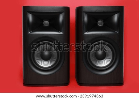 Modern wooden sound speakers on red background