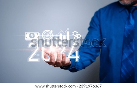 Man holding the year 2024 concept. A visionary businessman boldly embraces change, holding the key to unlocking his 2024 business success. Royalty-Free Stock Photo #2391976367